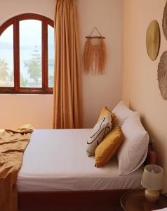 a bedroom with a bed with pillows and a window at Hotel Villa Margarit in Sarandë