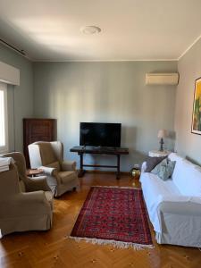 a living room with a tv and a couch and chairs at Golden Ravenna- large appartment in center in Ravenna