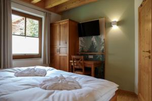 een slaapkamer met een bed, een bureau en een televisie bij Schwarzwald Chalets in Freudenstadt