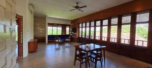 a living room with a table and chairs and windows at Sanur Seaview Hotel in Sanur