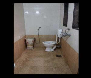 La salle de bains est pourvue de toilettes et d'un lavabo. dans l'établissement Hotel Rachana Residency, à Pune