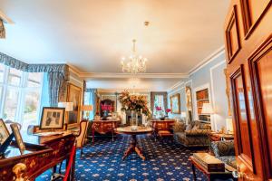 a living room filled with furniture and a chandelier at Plas Dinas Country House in Caernarfon