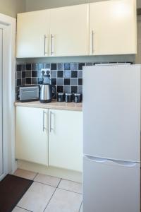 a kitchen with white cabinets and a tea kettle on the counter at Bell Street in Liverpool