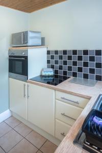 a kitchen with white cabinets and a stove top oven at Bell Street in Liverpool