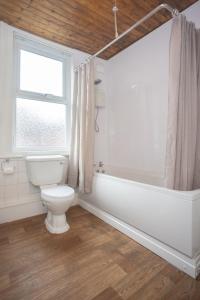 a bathroom with a toilet and a tub and a window at Bell Street in Liverpool