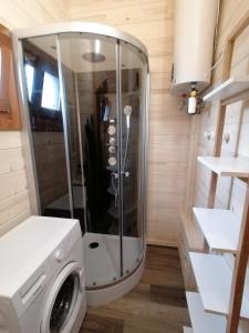 una ducha en una casa pequeña con lavadora en Chalet "L'aventure" calme et verdoyant - 6 pers, en Sulniac