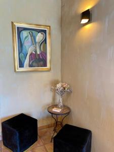 um vaso de flores sobre uma mesa ao lado de um quadro em Hotel Belvedere em Calvi