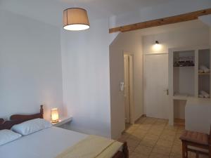1 dormitorio con 1 cama y pasillo con puerta en Villa Margarita, en Spetses