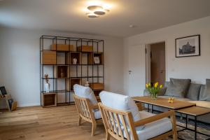 ein Wohnzimmer mit einem Tisch, Stühlen und einem Sofa in der Unterkunft Suite Home Apartments in Weimar