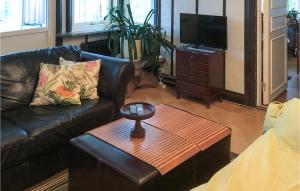 a living room with a leather couch and a table at Gorgeous Apartment In Bors With Wifi in Borås