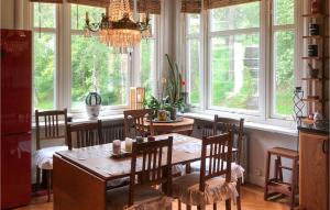 uma sala de jantar com mesa, cadeiras e janelas em Gorgeous Apartment In Bors With Wifi em Borås