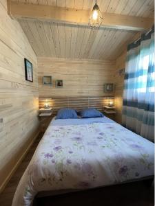 1 dormitorio con 1 cama en una habitación de madera en Chalet "L'aventure" calme et verdoyant - 6 pers, en Sulniac