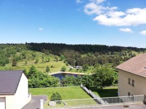 z góry widok na dom i jezioro w obiekcie Appartement accueillant au cœur de La Margeride w mieście Grandrieu