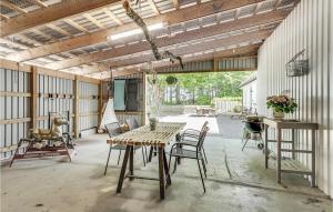 un granero con una mesa de madera y sillas en el patio en Stunning Apartment In Billund With Kitchen, en Billund