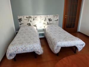 una camera con 2 letti e un comodino con di Le Comari a Milano