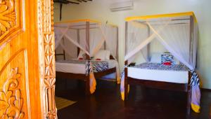 two beds in a room with at Zanzibar Dream Lodge in Bwejuu