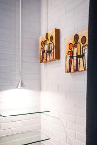 a bathroom with two paintings on the wall at Réva Residences and Pool in Monforte dʼAlba