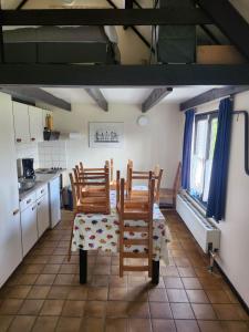uma cozinha com 2 cadeiras de madeira e uma mesa em Maison Sunpark Oostduinkerk 550 em Koksijde