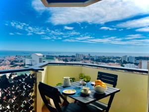 a table on a balcony with a view of the city at Studio Cascais with Sea view in Cascais