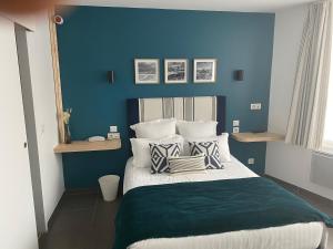 a bedroom with blue walls and a bed with pillows at Hôtel Chilhar in Espelette