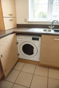 a kitchen with a washing machine and a sink at Chi-Amici-3bed home-St Neots-Near to train station in Saint Neots