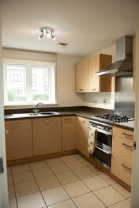 a kitchen with a sink and a stove top oven at Chi-Amici-3bed home-St Neots-Near to train station in Saint Neots