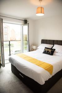 a bedroom with a large bed and a large window at Chi-Amici-3bed home-St Neots-Near to train station in Saint Neots