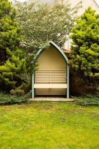 un cobertizo con un banco en medio de un patio en Chi-Amici-3bed home-St Neots-Near to train station en Saint Neots