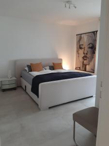 a white bedroom with a large white bed in it at 2 Zimmer Ferienwohnung mit Seeblick in Überlingen in Überlingen