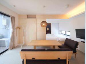 a living room with a table and a bedroom at East SQUARE Tokyo in Tokyo