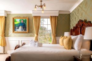 a bedroom with a large bed with a window at Plas Dinas Country House in Caernarfon