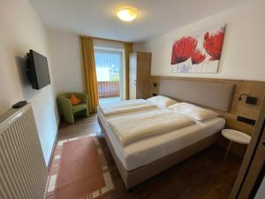 een slaapkamer met een groot bed en een televisie bij Haus Waldheim und Dependance in Scharnitz