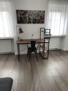 a room with a desk and a table with a chair at Propeller Gästehaus OG in Eppingen