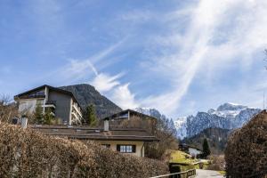 a house on a hill with mountains in the background at FeWo Berkristall mit Hallenbad in Berchtesgaden