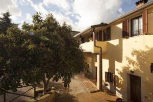 un edificio con un árbol delante de él en Il poggio dei tre contadini, en Ponte Felcino