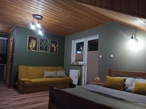 a living room with a bed and a couch at Apartament 4 osobowy in Kujan