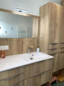 La salle de bains est pourvue d'un lavabo blanc et d'un miroir. dans l'établissement Le Touquet : Appt 4 pers face mer, à Le Touquet-Paris-Plage