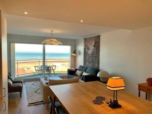 Sala de estar con mesa y vistas al océano en Le Touquet : Appt 4 pers face mer en Le Touquet-Paris-Plage