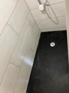 a bathroom with a white tile floor and a toilet at Maisonette La Quiétude in Wimereux