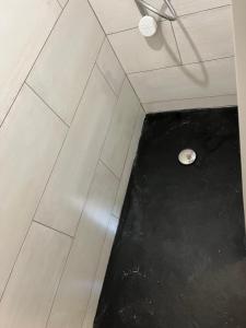 ein Badezimmer mit weißem Fliesenboden und einem WC in der Unterkunft Maisonette La Quiétude in Wimereux