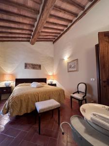 sypialnia z łóżkiem, krzesłem i umywalką w obiekcie La Casina w mieście Buonconvento