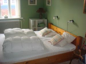 a large bed with white sheets and pillows on it at Penthouse Apartment Downtown - Hotel Sønderstrand Apartments in Skagen