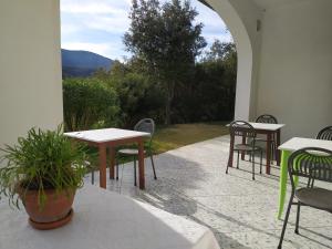 a patio with tables and chairs and a view of a mountain at B&B Casa Corbezzolo in Procchio