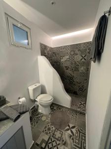 ein Badezimmer mit einem WC, einem Waschbecken und einer Badewanne in der Unterkunft White and Grey Tinos in Stení