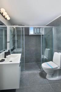 uma casa de banho com um WC e uma cabina de duche em vidro. em Urban Condo 12 - 2 Bdr em Nicósia