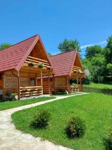 une cabane en rondins avec un toit rouge dans l'établissement Drveni raj Uvac, à Sjenica
