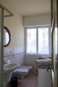 a bathroom with a sink and a toilet and a window at Casa Margherita Bellagio in Bellagio