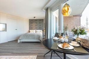 uma sala de estar com uma cama e uma mesa de jantar em NEU! Ferienwohnung Sunset Loft Wohlfuehlatmospaehre mit Weitblick in Westerland Sylt em Westerland