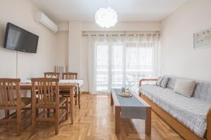 een woonkamer met een bank en een tafel bij Spacious Cozy Apartment in Athens in Athene