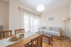 uma sala de estar com uma mesa e um sofá em Spacious Cozy Apartment in Athens em Atenas